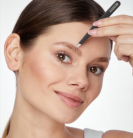 Mulher de olhos castanhos sorrindo, usando a pinça Nanobrow